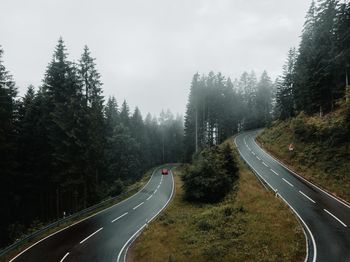 Road amidst trees against sky