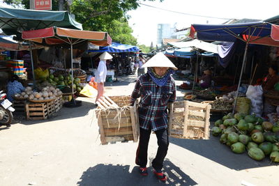 Rear view of man and woman for sale at market stall