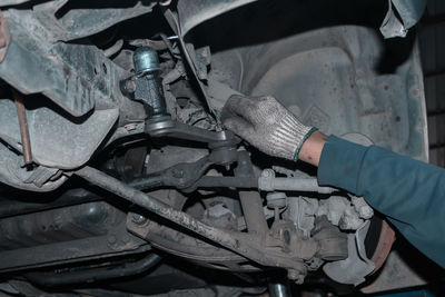 Midsection of mechanic repairing car