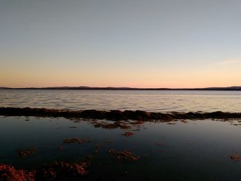 Scenic view of sea against clear sky at sunset