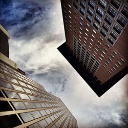 Low angle view of modern building against cloudy sky