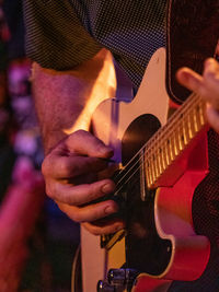 Midsection of man playing guitar