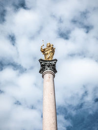 Low angle view of angel statue against cloudy sky