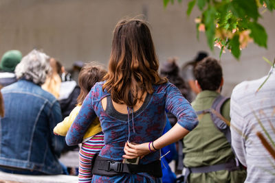 Rear view of people standing in city