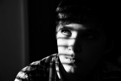 Close-up of boy looking away while sitting at home