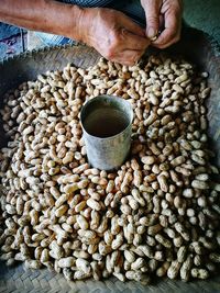 Cropped hands of person removing peanuts from shells
