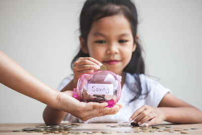 Cropped hand holding piggy bank for girl