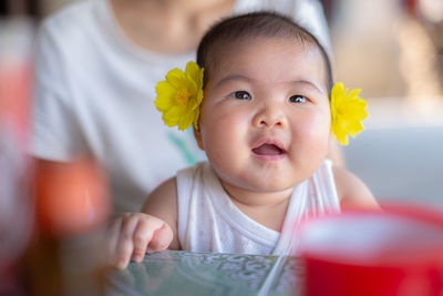 Portrait of cute baby girl holding flower