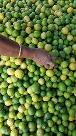 Cropped hand picking lemon at market