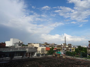 Buildings in city against cloudy sky