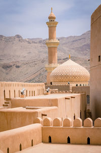 Minaret, dome and walls of medievel arabian fort of nizwa, oman.