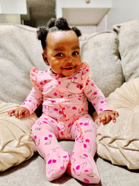 Portrait of cute baby girl on bed at home