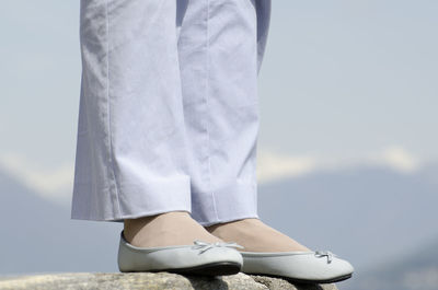 Low section of woman standing on rock