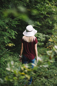 Rear view of woman standing against plants