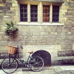 Bicycle parked against brick wall