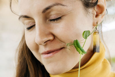 Happy woman with freshly cut sprout of microgreen closeup of farmer trying harvest healthy eating