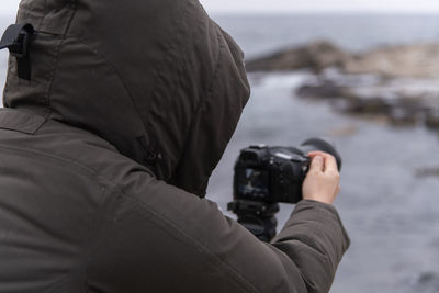 Midsection of man photographing in winter