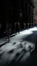 People walking on street against buildings in city