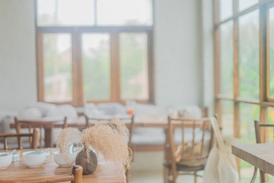 Empty chairs and table against window at home