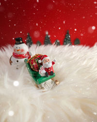 Close-up of christmas ornaments against red background