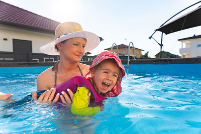 Baby girl with mother in swimming pool learn to swim. family lifestyle concept.