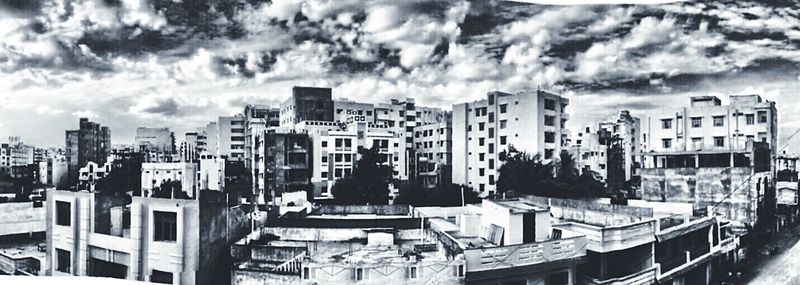 Buildings in city against cloudy sky