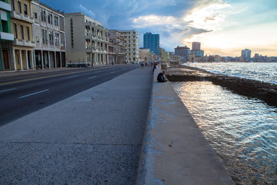 View of city street against cloudy sky