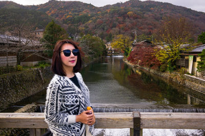 Portrait of young woman wearing sunglasses standing on mountain