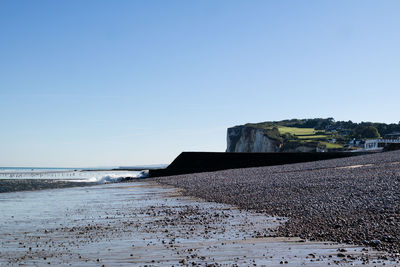 Scenic view of beach against clear blue sky