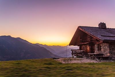 House on mountain against sky during sunset