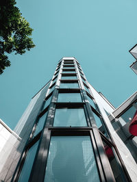 Low angle view of modern building against blue sky