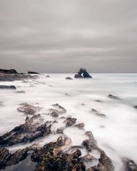 Scenic view of rocks in sea against sky