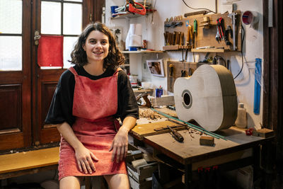 Woman luthier making guitars in her musical instrument workshop