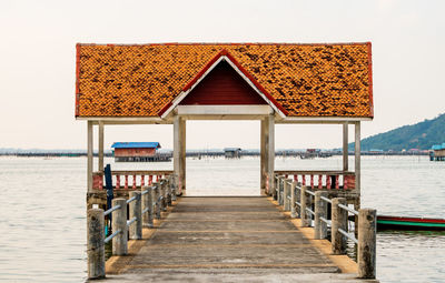 Pier on beach against clear sky