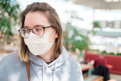 Close-up of woman wearing flu mask standing outdoors