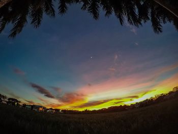 Scenic view of silhouette field against sky at sunset