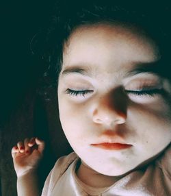 Close-up of little girl sleeping on bed at home