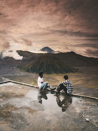 People riding motorcycle on mountain against sky