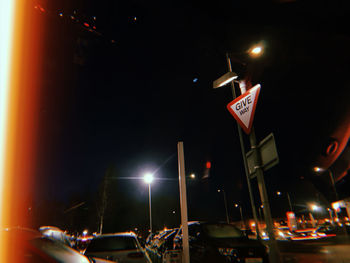 Low angle view of illuminated street lights at night