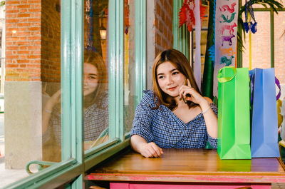 Woman using phone while sitting at table in restaurant