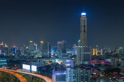 Illuminated buildings in city against sky at night