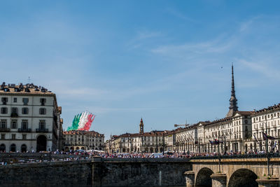 Buildings in city against cloudy sky