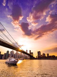 View of suspension bridge over river against cloudy sky