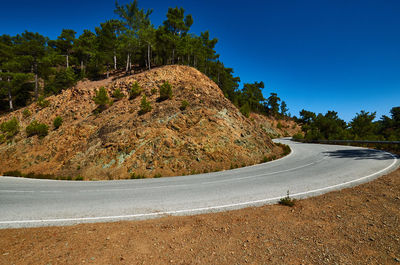 Scenic view of mountain road against clear blue sky