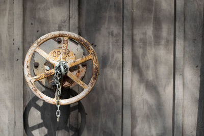 Close-up of machine valve on wooden wall