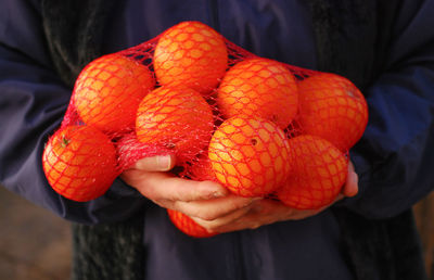 Close-up of hand holding orange