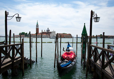 View of wooden post in canal against cloudy sky