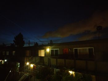 Illuminated street light against sky at night