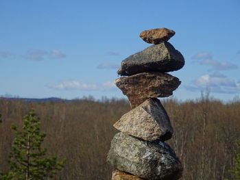Stack of rocks on field against sky
