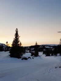 Scenic view of snow covered field against sky during sunset